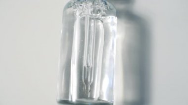 Şeffaf Cam Şişe Mock Up 'taki Kozmetik Pipette. Serum Cilt Bakımı 'nın Beyaz Arkaplanda Gölgeler Efekti Üzerine Kapanışı. 4k Görüntü.