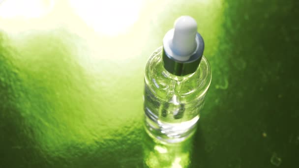 Zbliżenie Butelki Kryształowego Szkła Pipetą Wewnątrz Obracającą Się Zielonej Powierzchni — Wideo stockowe