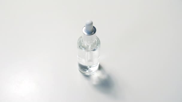 透明玻璃瓶模型中的化妆品管道 白底背景下血清素护肤凝胶的特写及效果观察 4K图象 — 图库视频影像