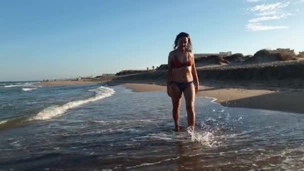 ビキニを着てビーチの上を歩く女の子 — ストック動画