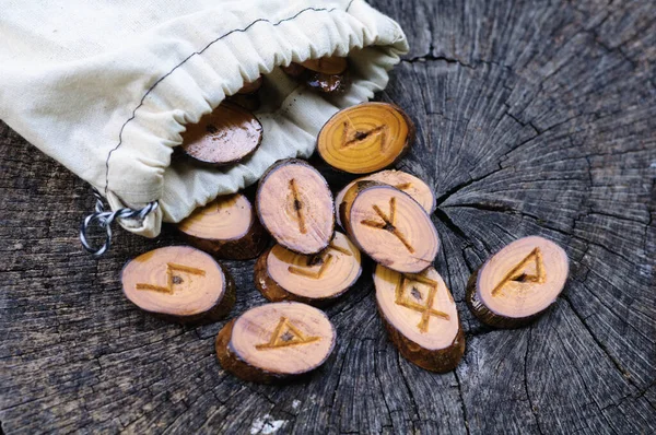 Runas de madeira em um saco em um toco velho — Fotografia de Stock