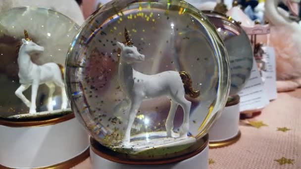 A glass snow ball with unicorn figurine inside — Stock Video