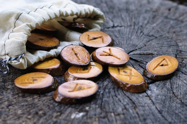 Runas de madeira em um saco em um toco velho — Fotografia de Stock