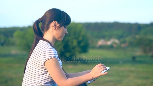 Chica morena escribe mensaje en una tableta — Vídeos de Stock