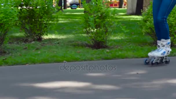 Dívka na kolečkových bruslích v městském parku — Stock video