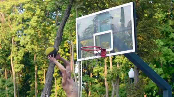 Un jugador en streetball hace un slam dunk. Entrenamiento de baloncesto al aire libre — Vídeo de stock