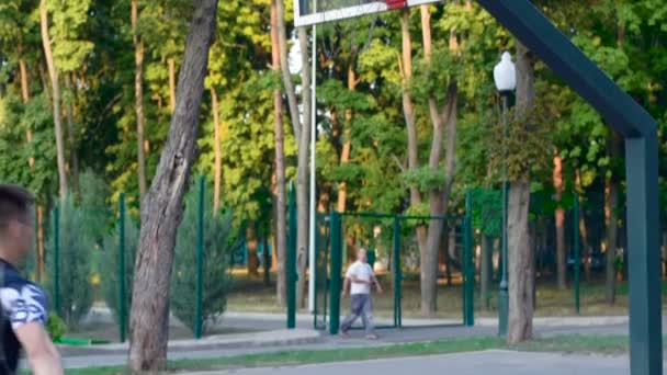 En spelare i streetball gör en slam dunk. Basket träning utomhus — Stockvideo