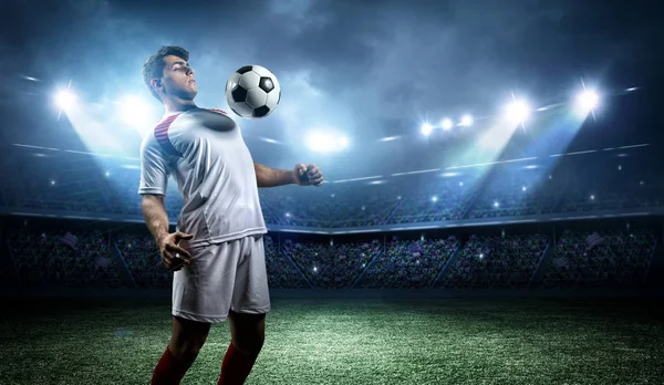 Jugador de fútbol resiste una pelota con su pecho en el estadio — Foto de Stock