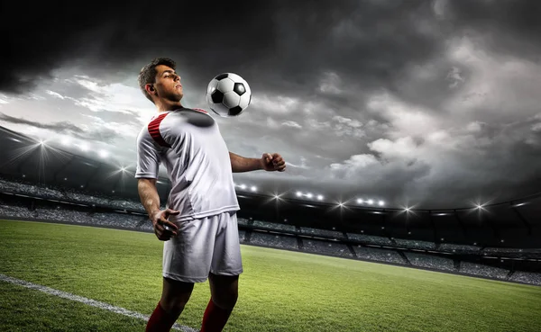 Jugador de fútbol resiste una pelota con su pecho en el estadio — Foto de Stock