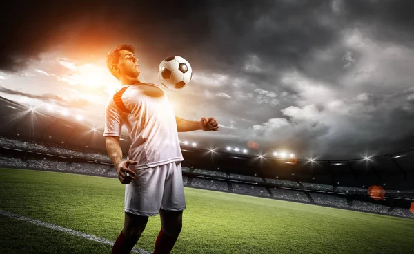 Jugador de fútbol resiste una pelota con su pecho en el estadio — Foto de Stock