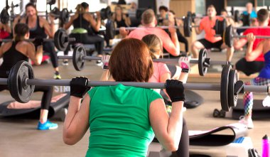 Kadınlar grup fitness sınıfında enerjik egzersizler yapıyorlar..