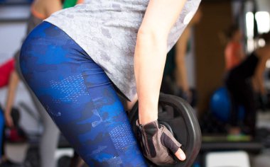 Woman doing squats with weights for a perfect butt.