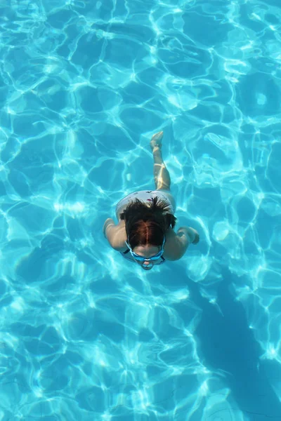 Giovane ragazza che nuota sott'acqua nell'acqua limpida della piscina — Foto Stock