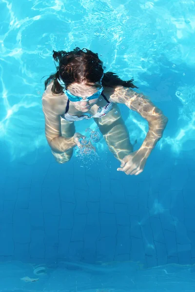 Young girl swimming underwater in the clear water of the pool — Stock Photo, Image