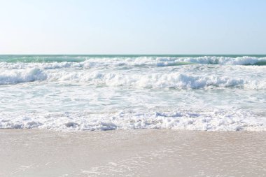 Nefes kesen dalgalar kumsalda çalışıyor. Güneşli gün ve deniz fırtınası. Azgın doğanın güzelliği