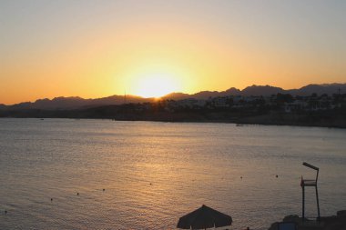 Sharm El Sheikh 'de günbatımı manzarası. Deniz, dağlar ve dev günbatımı manzarası. Rahatlama ve özgürlük atmosferi. Mükemmel tatil.
