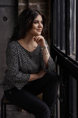 Pretty young girl posing in stylish loft interior