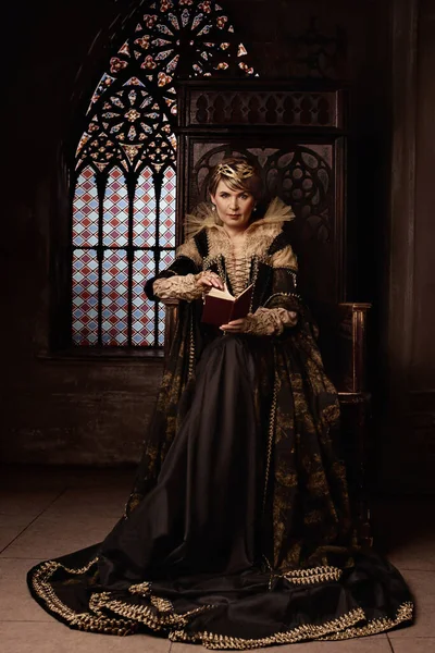 Kraliçe kostümü giymiş olgun bir kadın.