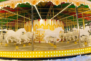 Atlıkarınca. Geceleri kış fuarında beyaz lüks bir atlı karınca.