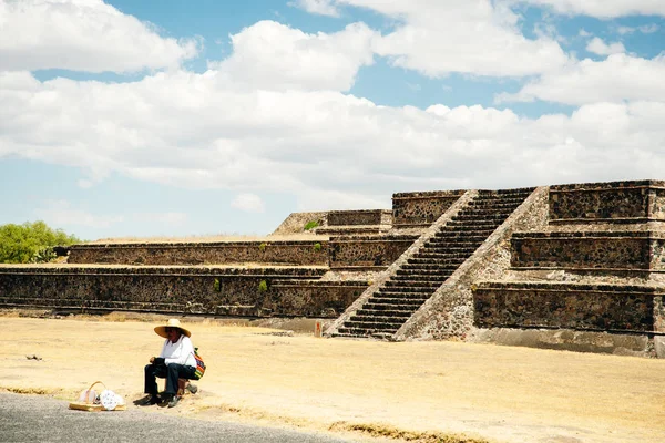 Теотиуакан, Мексика - июнь 2014 г. Продавец сувениров сидит у пирамиды — стоковое фото
