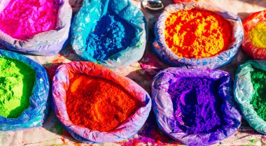 Çantalarda çok parlak renkli boya tozları ve küçük bir kaşık. Holi bayramı için resimler.