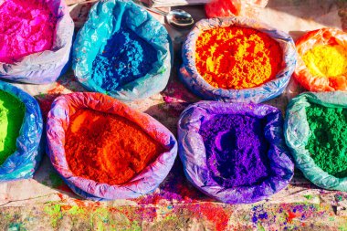 Çantalarda çok parlak renkli boya tozları ve küçük bir kaşık. Holi bayramı için resimler.