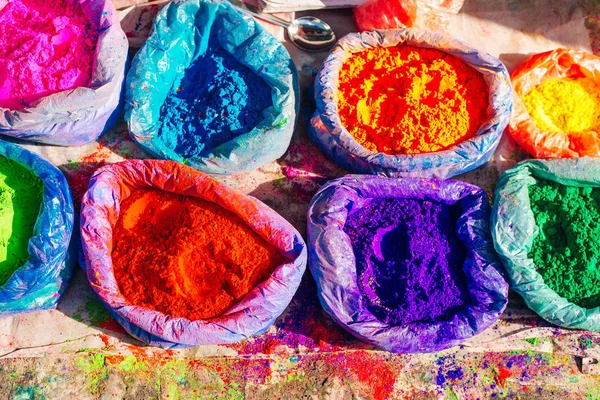 very bright multicolored paint powders in bags and a small spoon. paints for the holiday of Holi