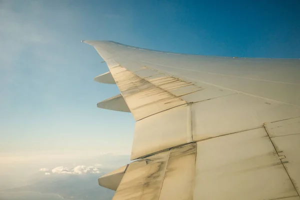 Flugzeug Fenster Blick auf Wolken und Inseln von Meer und Flugzeugflügel umgeben. Reisekonzept — Stockfoto