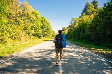Yolda büyük bir sırt çantası olan bir gezgin.