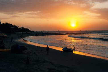 Mancora, Peru - Nisan 2019 günbatımında plajda güneş ışığı denize yansıyor.