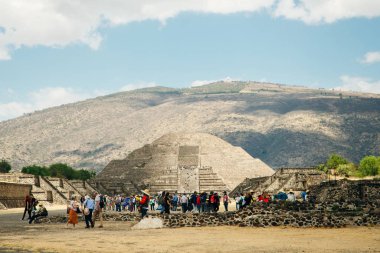 Teotihuacan, Meksika - Haziran 2018 hediyelik eşya satıcısı piramidin yanında oturuyor.