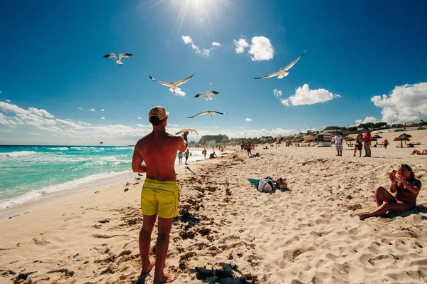 Mexico - Playa Delfines - December, 2019 Beautiful beach in Cancun. Tourist feeds seagulls — Stock Photo, Image