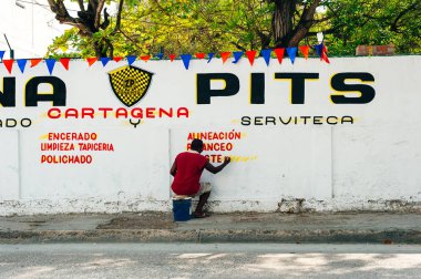 Adam duvarlara reklam çiziyor Kartagena, Kolombiya sokaklarında - Haziran 2019