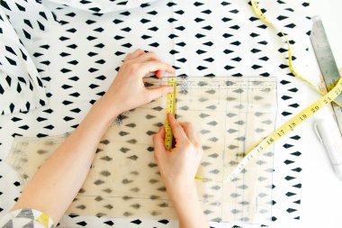 Terzinin en iyi iş yeri manzarası. Terzi robot resimdeki detayları kesiyor. Terzi, pembe kumaşı makasla keser..