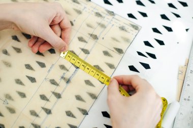 Genç bir kürkçü kadının yakın çekimi, bir terzi doğal bir kürkü kesiyor..