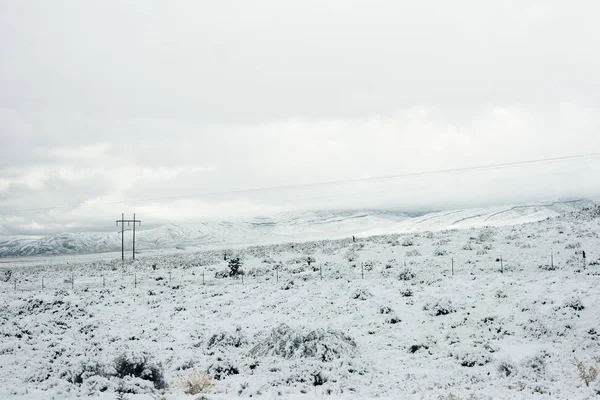 Pliez le long d'une route enneigée dans un cadre montagneux en hiver — Photo