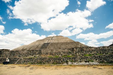 Teotihuacan, Meksika - Haziran 2018 hediyelik eşya satıcısı piramidin yanında oturuyor.