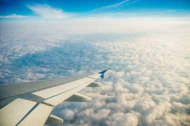 Deniz ve uçak kanadıyla çevrili bulutların ve adaların uçak penceresi manzarası. Seyahat kavramı