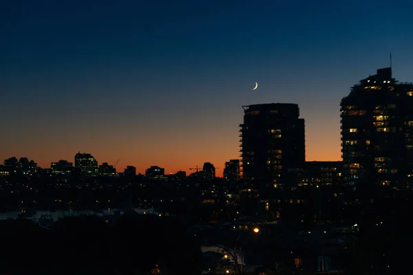 Utsikt över byggnader upplysta i staden vid kusten i Vancouver, Kanada — Stockfoto