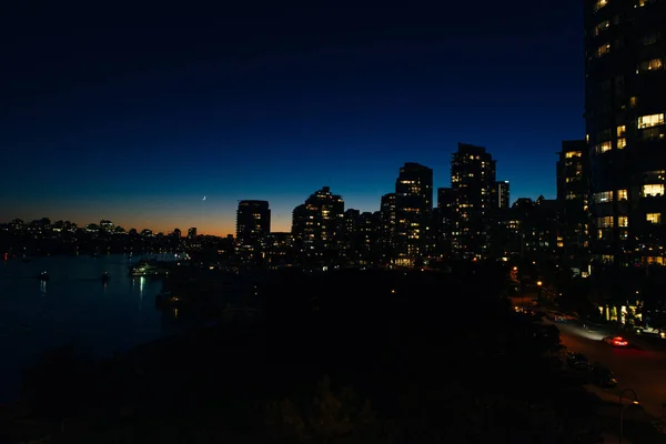 Vista de edifícios iluminados na cidade na costa em Vancouver, Canadá — Fotografia de Stock