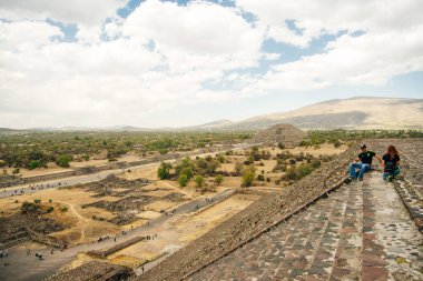 Teotihuacan, Meksika - Haziran 2018 hediyelik eşya satıcısı piramidin yanında oturuyor.