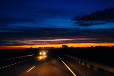 Gece gün batımında köprüde araba silueti