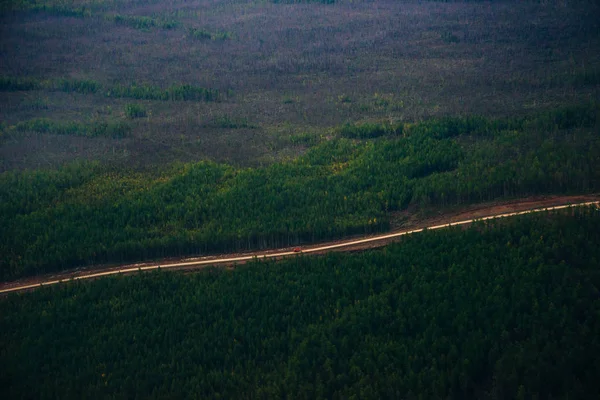 Vista dall'alto della strada attraverso il bosco con una macchina rossa — Foto Stock