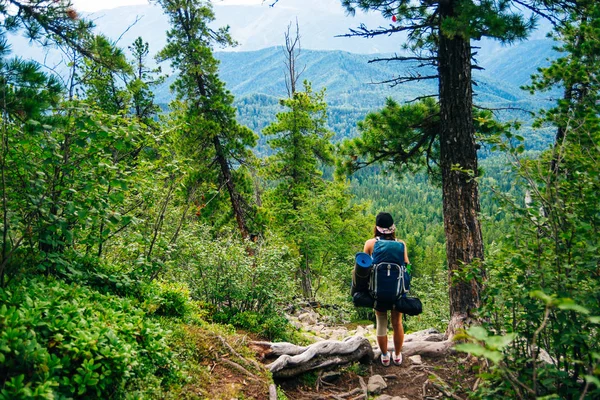 Mulher caminhante em caminhada com uma grande mochila vista traseira — Fotografia de Stock