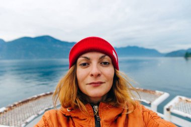 Gezgin gölün arka planında özçekim yapıyor. Vancouver, Kanada