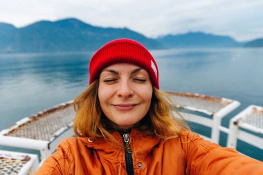 Gezgin gölün arka planında özçekim yapıyor. Vancouver, Kanada