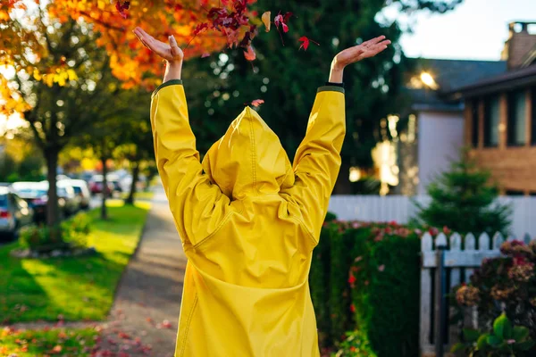 Beautiful girl in the yellow raincoat walking outdoors in autumn. Young woman enjoying autumn weather. — Stock Photo, Image