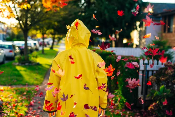 Όμορφο κορίτσι με το κίτρινο αδιάβροχο που περπατάει στην ύπαιθρο το φθινόπωρο. Νεαρή γυναίκα απολαμβάνει φθινοπωρινό καιρό. — Φωτογραφία Αρχείου