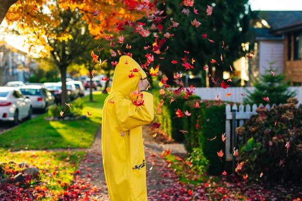 Beautiful girl in the yellow raincoat walking outdoors in autumn. Young woman enjoying autumn weather. — Stock Photo, Image