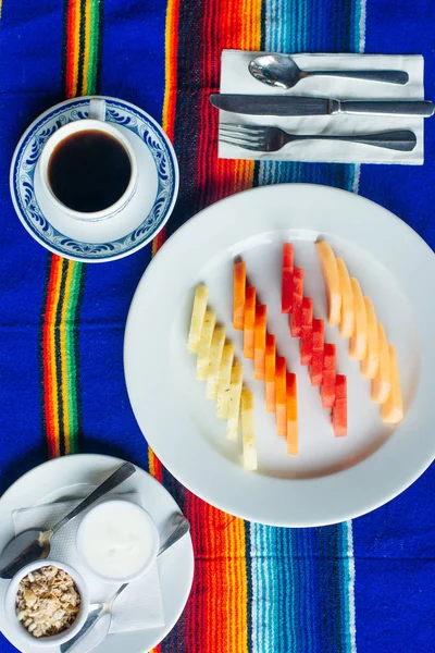 Fette di frutta ben tagliate su un piatto bianco in un ristorante. Cibo messicano — Foto Stock